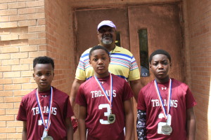 Coach Walter Dunn, pictured with three captains from the DOT Trojans